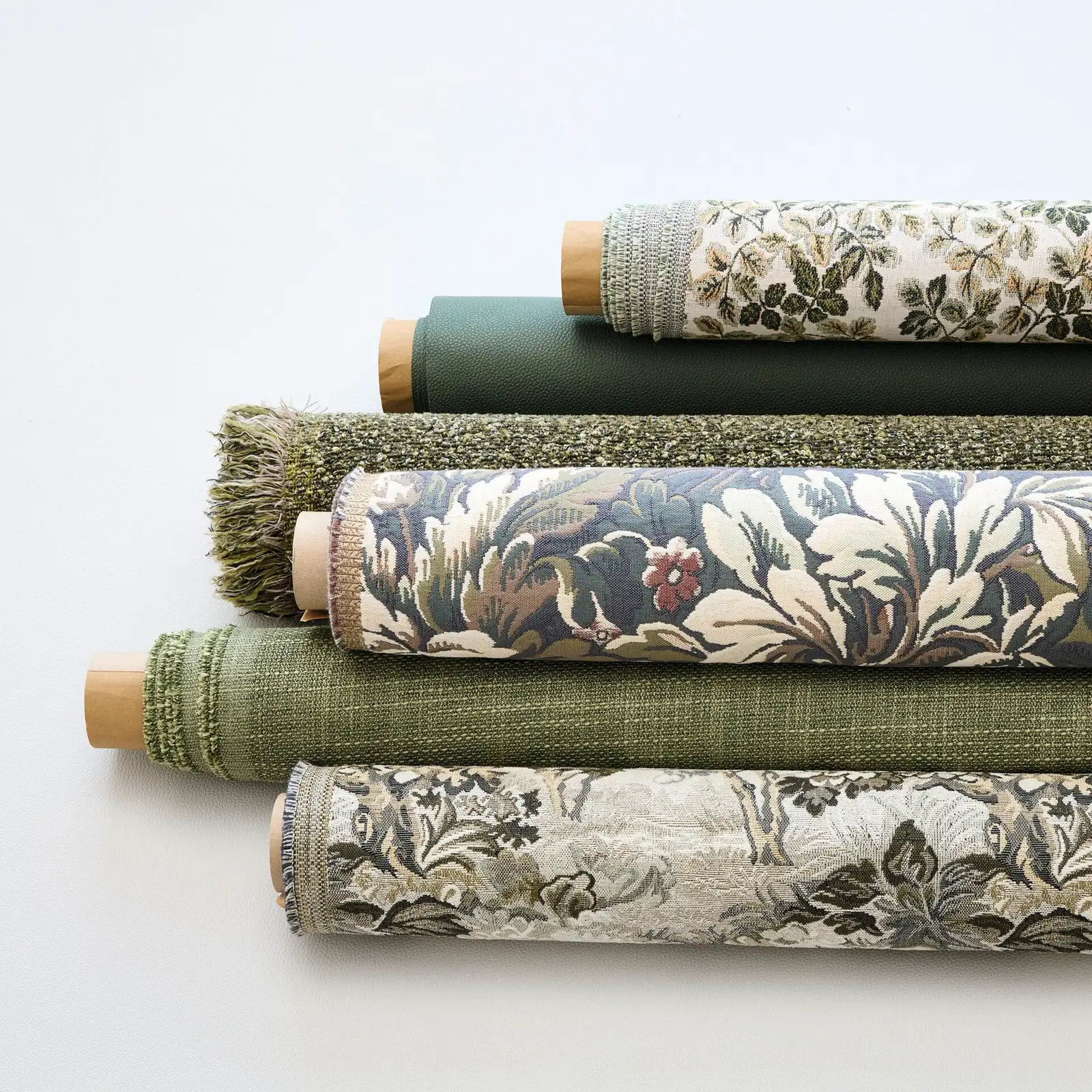 Rolls of green and botanical print upholstery fabric