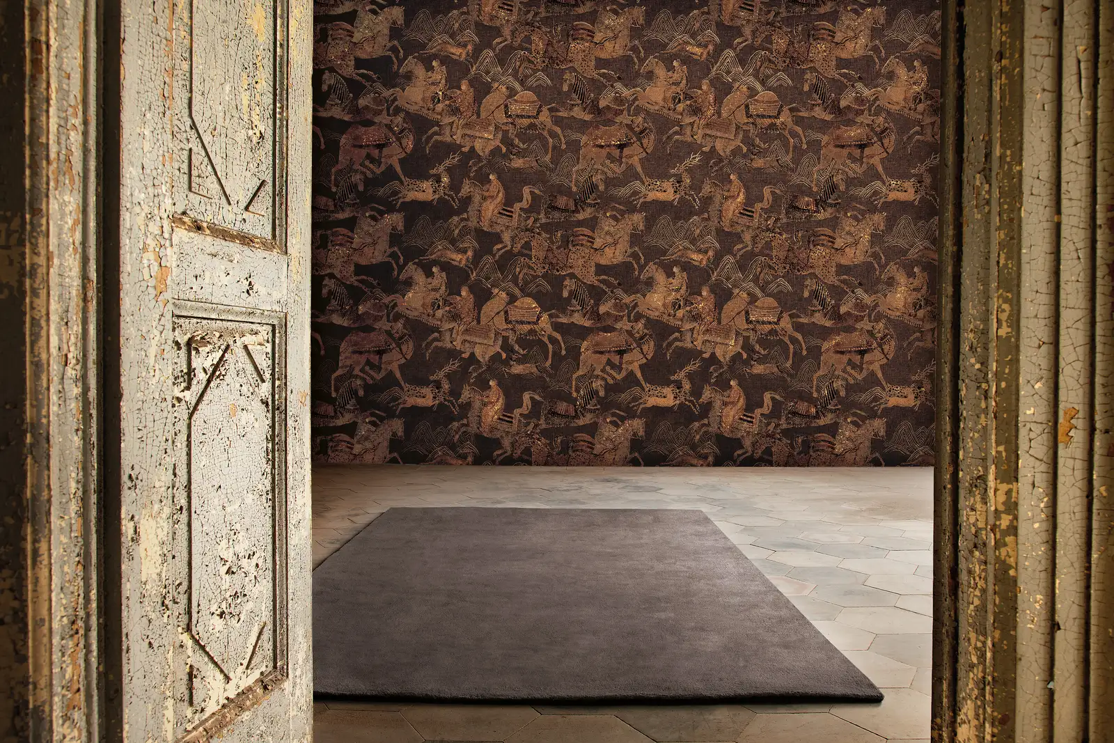 Antique carved door opening onto a patterned wallcovering and rug