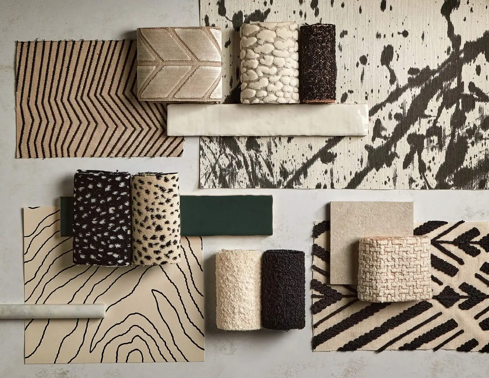 Flat lay of textile and wallcovering samples in black, cream and tan